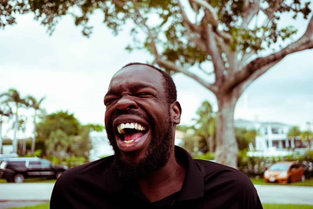 man in black polo shirt smiling